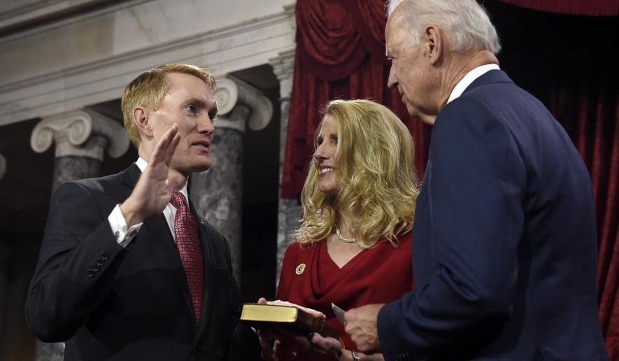 Vice President Joe Biden administers the Senate oath to Sen. James Lankford R-Okla. during a ceremonial re-enactment swearing-in ceremony, Tuesday, Jan. 6, 2015, in the Old Senate Chamber on Capitol Hill in Washington. Lankford's wife Cindy is at center. (AP Photo/Susan Walsh)