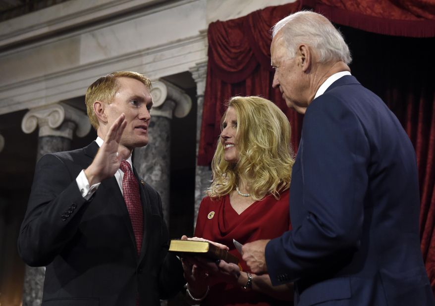 Vice President Joe Biden administers the Senate oath to Sen. James Lankford R-Okla. during a ceremonial re-enactment swearing-in ceremony, Tuesday, Jan. 6, 2015, in the Old Senate Chamber on Capitol Hill in Washington. Lankford's wife Cindy is at center. (AP Photo/Susan Walsh)