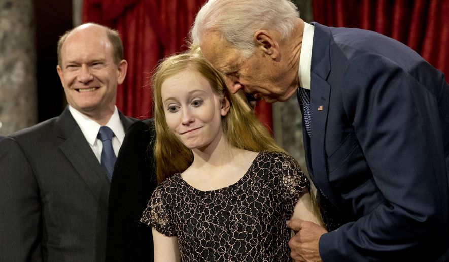 Vice President Joe Biden leans in to say something to Maggie Coons, next to her father Sen. Chris Coons, D-Del., after Biden administered the Senate oath to Coons during a ceremonial re-enactment swearing-in ceremony, Tuesday, Jan. 6, 2015, in the Old Senate Chamber of Capitol Hill in Washington. (AP Photo/Jacquelyn Martin)