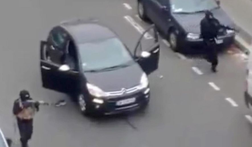 A still from a home video shows gunmen firing their weapons outside the newspaper Charlie Hebdo&#x27;s Paris office. (Associated Press)