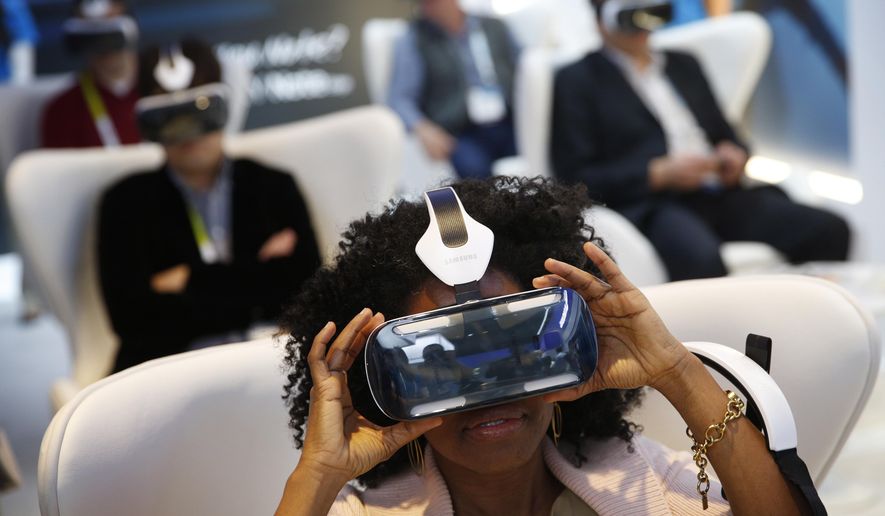 Yasmin Moorman looks into the Galaxy Gear VR headset at the Samsung booth during the International CES, Tuesday, Jan. 6, 2015, in Las Vegas. (AP Photo/John Locher)