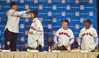 National Baseball Hall of Fame inductees Craig Biggio, second from right, and Pedro Martinez, right, react with laughter as John Smoltz, left, stands on his chair to place a cap on Randy Johnson&#39;s head, after they received Hall of Fame uniforms during a press conference, Wednesday, Jan. 7, 2015, in New York. The four will be inducted into the hall in Cooperstown, N.Y., in July.  (AP Photo/Bebeto Matthews)