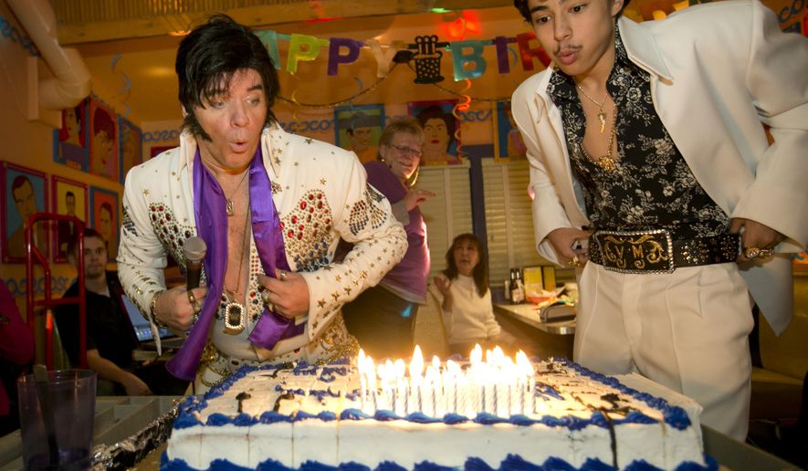Elvis Presley impersonators Jimi Cochrane, left, of Houston, and Mansour Spears, 15, of Austin, blow out the candles at Elvis&#39; 80th birthday party at Chuy&#39;s restaurant in Austin, Texas, Thursday, Jan. 8, 2015. (AP Photo/Austin American-Statesman, Jay Janner)
