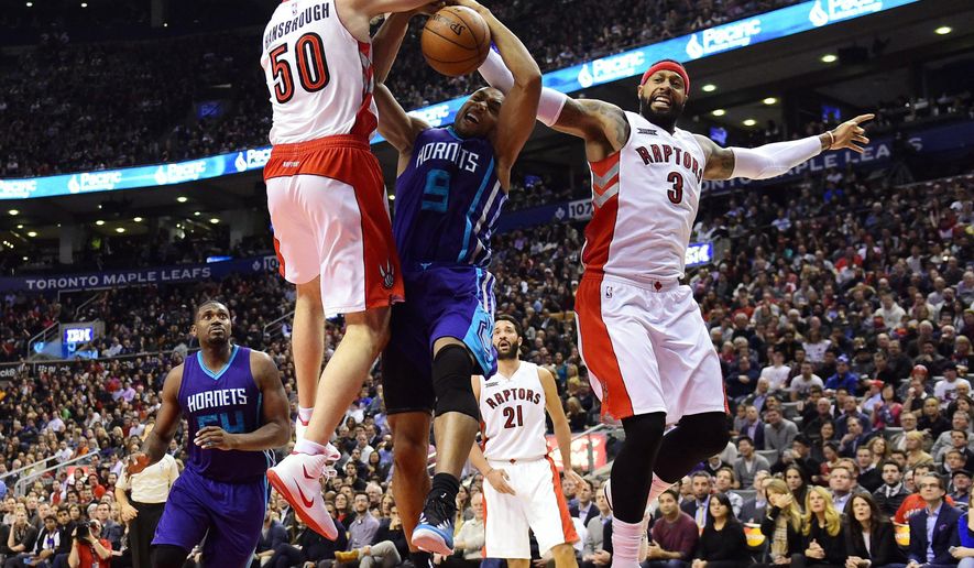 Charlotte Hornets&#x27; Gerald Henderson (9) is fouled as Toronto Raptors&#x27; Tyler Hansbrough (50) and James Johnson defend during the second half of an NBA basketball game in Toronto on Thursday, Jan, 8, 2015. (AP Photo/The Canadian Press, Frank Gunn)