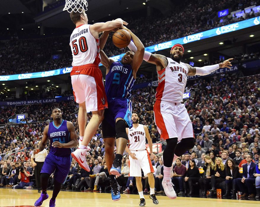 Charlotte Hornets&#39; Gerald Henderson (9) is fouled as Toronto Raptors&#39; Tyler Hansbrough (50) and James Johnson defend during the second half of an NBA basketball game in Toronto on Thursday, Jan, 8, 2015. (AP Photo/The Canadian Press, Frank Gunn)