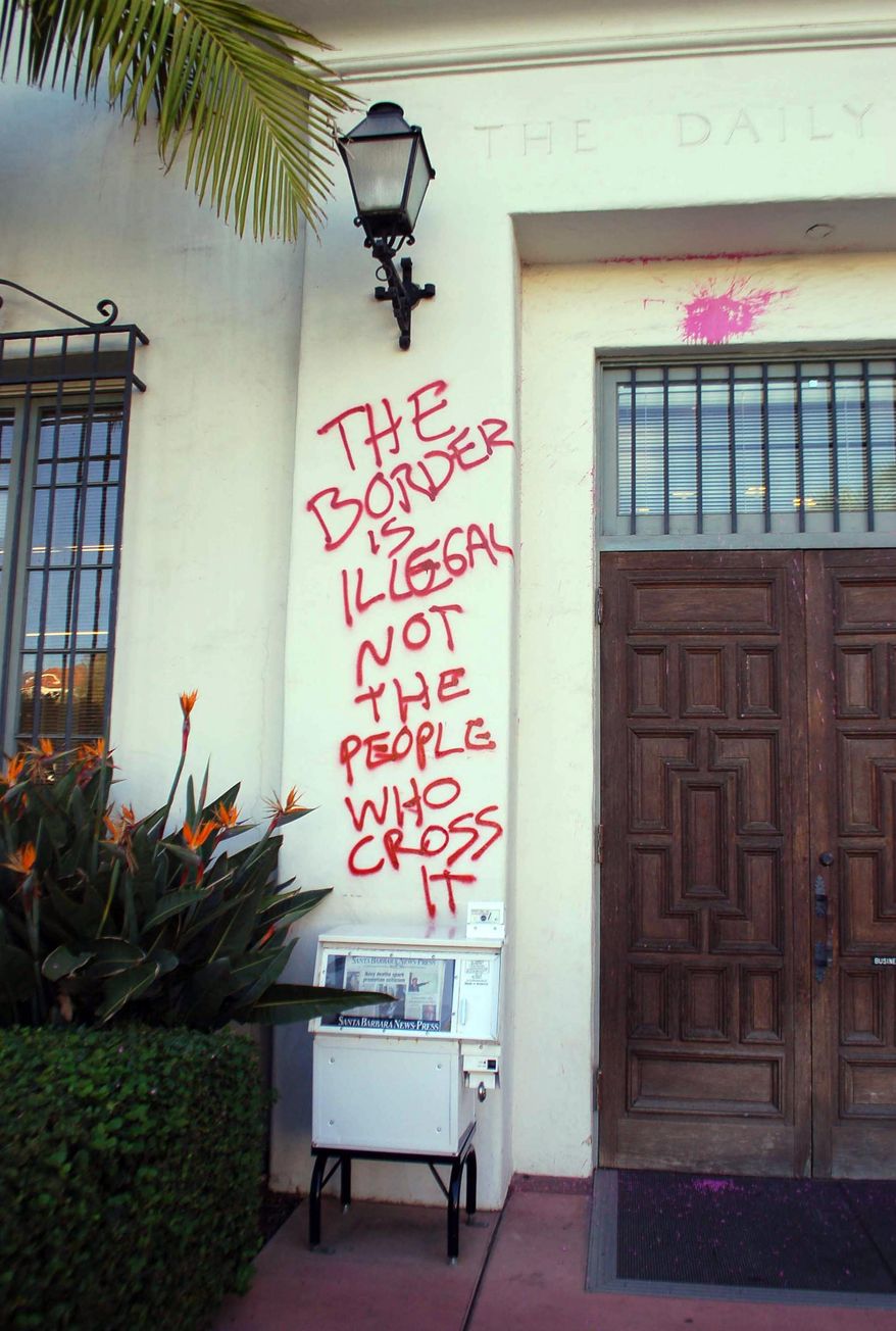 Graffiti and paint are splattered on the entrance to the Santa Barbara News-Press building Thursday, Jan. 8, 2015, in Santa Barbara, Calif. The newspaper has received criticism since running a story and photo about California allowing immigrants who entered the country illegally being allowed to apply for driver's licenses. Saturday's headline read: "Illegals line up for driver's licenses." Donald K. Katich, the News-Press director of news operations, says in a statement that the newspaper has used the term for nearly 10 years and it is appropriate. (AP Photo/Santa Barbara News-Press, Scott Steepleton) MANDATORY CREDIT