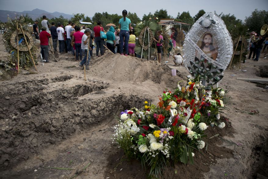Flowers adorn the fresh grave of slain 18-year-old Antonio Sanchez Valencia as mourners bury another victim from the same shooting in Apatzingan, Michoacan state, Mexico, Thursday, Jan. 8, 2015. (AP Photo/Rebecca Blackwell) ** FILE **