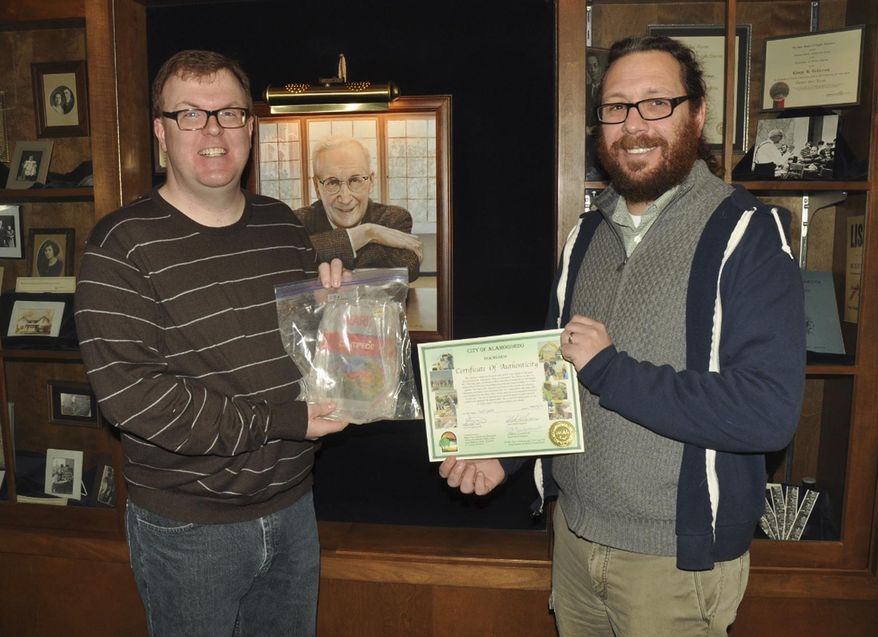 In this Jan. 7, 2015 photo provided by the University of North Dakota, Curt Hanson, left, director of University of North Dakota’s Department of Special Collections, holds sealed bag containing an Atari 2600 gaming system cartridge for the 1980s-era game Centipede in Grand Forks, N.D. The cartridge was unearthed recently during an archaeological dig in an old New Mexico landfill. UND history professor Bill Caraher, right, who was part of that excavation and an associated documentary film about the dig, purchased the cartridge from the city of Alamogordo, N.M., and handed it over to UND Special Collections this week. (AP Photo/Courtesy of the University of North Dakota, Brian Baier)