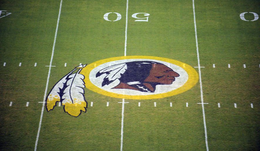 In this Aug. 28, 2009 file photo, the Washington Redskins logo is seen on the field before the start of a preseason NFL football game in Landover, Md. The Justice Department says it is intervening in a trademark dispute concerning the team name of the Washington Redskins. A June ruling from the U.S. Patent and Trademark Office stripped the professional football team of trademark protection,  (AP Photo/Nick Wass, File)