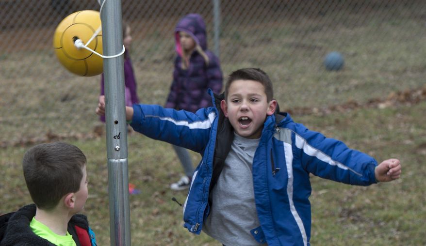 Austin Bryant celebrates his victory at tetherball with Hogan Conder during recess at Marlin Elementary School in Bloomington, Ind. (Associated Press)
