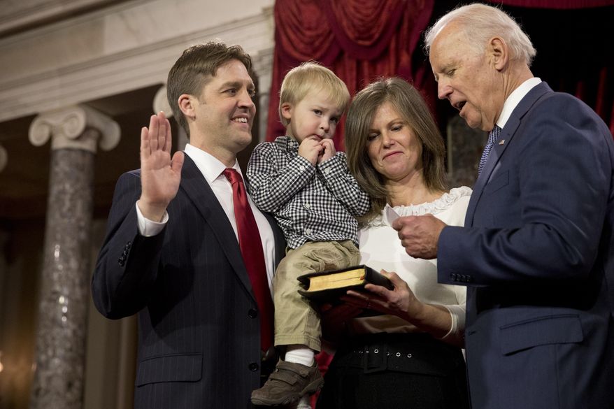 Vice President Joe Biden administers the Senate oath to Sen. Ben Sasse, R-Neb., holding his son Augustin, next to wife Melissa Sasse, during a ceremonial re-enactment swearing-in ceremony, Tuesday, Jan. 6, 2015, in the Old Senate Chamber of Capitol Hill in Washington. (AP Photo/Jacquelyn Martin)