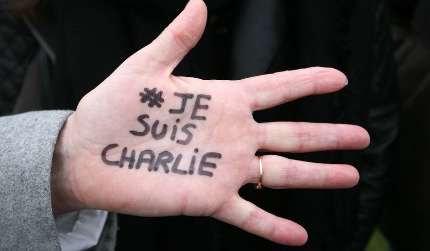 Brigitte Le Blein, of Nice, shows her hand reading &quot;I am Charlie&quot; during a silent march for victims of the shooting at the satirical newspaper Charlie Hebdo, Saturday, Jan. 10, 2015, in Nice, southeastern France. Ten journalists and two policemen were killed on Jan. 7 in a terrorist attack at the Charlie Hebdo headquarters in Paris. (AP Photo/Lionel Cironneau)