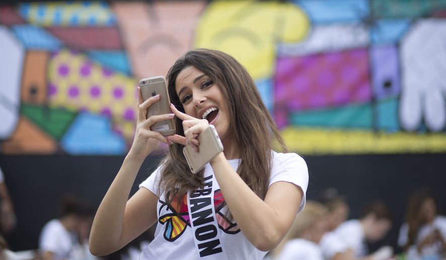 Miss Lebanon, Saly Greige, poses for photos after she painted on a wall in Miami&#x27;s Wynwood area, Sunday, Jan. 11, 2015. Miss Universe contestants visited pop artist Romero Britto&amp;#8217;s studio for an interactive painting event. (AP Photo/J Pat Carter)