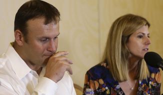 Former Miami Dolphins fullback Rob Konrad, left, listens while his wife Tammy, right, responds to a question during a news conference where he told about his ordeal of swimming nine miles to shore after he fell off his boat while fishing last week off the South Florida coast, Monday, Jan. 12, 2015, in Plantation, Fla. Konrad fell off his 36-foot-boat while fishing alone. The boat was on auto pilot and floated away. (AP Photo/Lynne Sladky)