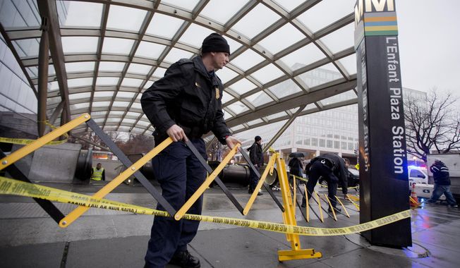 Metro Transit Police officers secure the entrance to L’Enfant Plaza Station in Washington, Monday, Jan. 12, 2015, following an evacuation. Metro officials say one of the busiest stations in downtown Washington has been evacuated because of smoke.  Authorities say the source of the smoke is unknown.   (AP Photo/Manuel Balce Ceneta)