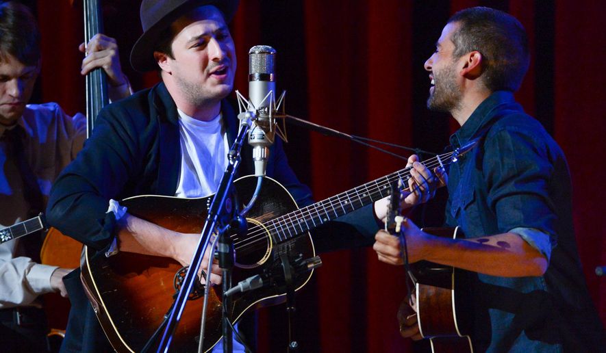 FILE - In this Sept. 29, 2013 file photo, musicians Marcus Mumford, left, and Oscar Isaac perform together during "Another Day, Another Time: Celebrating the Music of Inside Llewyn Davis" at The Town Hall in New York. Fans of the Coen brothers' amused, affectionate portrait of the 1960s Greenwich Village folk scene _ and of banjo-playing, guitar-plucking Americana in general _ will relish this recording of a 2013 New York concert celebrating the music of the movie "Inside Llewyn Davis." (Photo by Evan Agostini/Invision/AP, File)