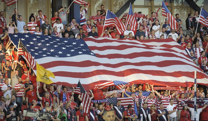 FILE - In this Oct. 16, 2012, file photo, United States soccer fans cheer as they unfurled a large American flag before a World Cup qualifying soccer match against Guatemala in Kansas City, Kan. The start of the final round of World Cup qualifying in North and Central America and the Caribbean will be moved up by three months to November 2016. Seeking its eighth straight World Cup berth, the United States has a bye until the fourth round, when it will be in a four-nation group with double match dates Nov. 7-17, 2015; March 21-29, 2016; and Aug. 29-Sept. 6, 2016.  (AP Photo/Reed Hoffmann, File)