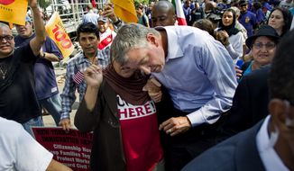 Bill de Blasio, Democratic nominee for New York mayor, leans over to listen to a woman after he spoke at a march and rally highlighting immigration reform Saturday, Oct. 5, 2013, in New York. (AP Photo/Craig Ruttle)