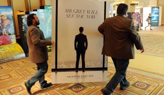 Sheldon Domke, left, and Adam Mast move an advertisement for the upcoming film &quot;Fifty Shades of Grey&quot; during a Las Vegas convention in 2014. The film is set for release on Feb. 13. (Photo by Chris Pizzello/Invision/AP)