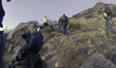 This March 16, 2014, photo of an Albuquerque Police Department lapel camera still, shows a standoff with James Boyd, 38, before firing six shots at the man. Lawyers for two Albuquerque police officers say both will face charges in the March killing of Boyd a homeless camper, a shooting that generated sometimes violent protests around the city and sparked a federal investigation. (AP Photo/Albuquerque Police Department, File)