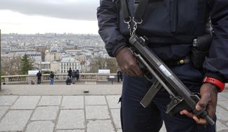A French police officer patrols around the Sacre Coeur basilica at Montmartre district, in Paris,, Monday, Jan. 12, 2015. France on Monday ordered 10,000 troops into the streets to protect sensitive sites after three days of bloodshed and terror, amid the hunt for accomplices to the attacks that left 17 people and the three gunmen dead. (AP Photo/Jacques Brinon)