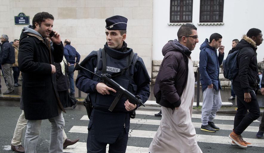In this Friday Jan. 9, 2015, file photo, a French police officer stands guard outside the Grand Mosque as people arrive for Friday prayers, Paris. Firebombs and pigs&#x27; heads are being tossed at mosques and women in veils have been insulted in a surge of anti-Muslim acts since last week&#x27;s murderous assault on the newsroom of a satirical Paris paper, according to a Muslim who tracks such incidents in France. (AP Photo/Michel Euler, File)