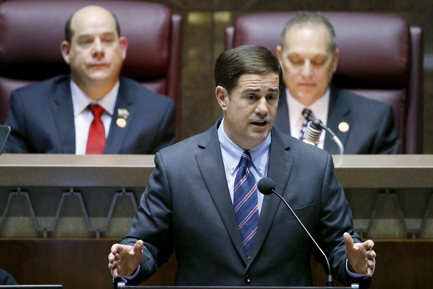 Arizona Republican Gov. Doug Ducey, front, gives his state-of-the-state address as Arizona House speaker David Gowan, left, R-Sierra Vista, and Arizona Senate President Andy Biggs, right, R-Gilbert, listen at the Arizona Capitol Monday, Jan. 12, 2015, in Phoenix. (AP Photo/Ross D. Franklin)