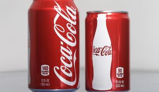 A 7.5-ounce can of Coca-cola, right, is posed next to a 12-ounce can for comparison, Monday, Jan. 12, 2015 in Philadelphia. As people cut back on soda, the two beverage giants, Coke and Pepsi, are increasingly pushing smaller cans and bottles they say contain fewer calories and induce less guilt. (AP Photo/Matt Rourke)