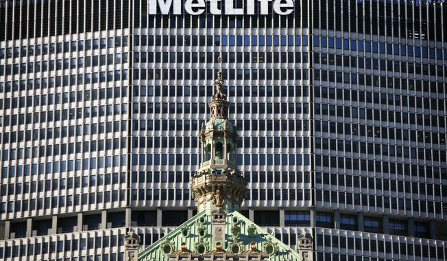 FILE - In this April 16, 2009, file photo, the MetLife building overlooks a shorter building in New York. MetLife said Tuesday, Jan. 13, 2015, that it is going to ask a federal judge to review its designation as a “too big to fail” company. (AP Photo/Mark Lennihan, File)