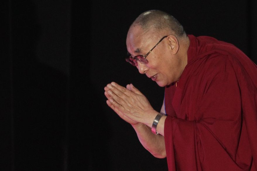 Tibetan spiritual leader the Dalai Lama greets the audience as he arrives to speak on &quot;A Human Approach to World Peace&quot; at Presidency College in Kolkata, India, Tuesday, Jan. 13, 2015. (AP Photo/Bikas Das)