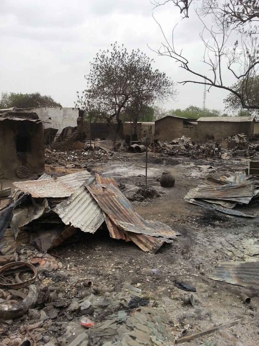 FILE - In this Sunday April. 21, 2013 file photo taken with a mobile phone, the ruins of burnt out houses stand in Baga village in Nigeria. Hundreds of bodies too many to count remain strewn in the bush in Nigeria from an Islamic extremist attack that Amnesty International suggested Friday is the "deadliest massacre" in the history of Boko Haram. Mike Omeri, the government spokesman on the insurgency, said fighting continued Friday for Baga, a town on the border with Chad where insurgents seized a key military base on Jan. 3 and attacked again on Wednesday. "Security forces have responded rapidly, and have deployed significant military assets and conducted airstrikes against militant targets," Omeri said in a statement. (AP Photo/Haruna Umar, file )
