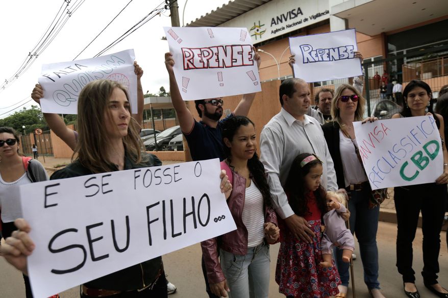 FILE - In this Dec. 18, 2014 file photo, relatives and friends of patients protest for the legalization of cannabidiol, a marijuana derivative that's banned in Brazil, outside the Health Surveillance Agency (ANVISA) in Brasilia, Brazil. On Wednesday, Jan. 14, 2015, for the first time Brazil approved the use of the marijuana derivative to treat people suffering from epilepsy, multiple sclerosis and schizophrenia among other disorders. (AP Photo/Eraldo Peres, File)
