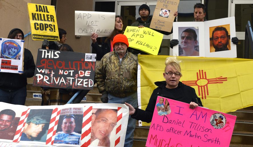 Demonstrators gather in front of Albuquerque police headquarters Wednesday, Jan. 14, 2015 to protest a police shooting that happened Tuesday that left a suspect dead. Albuquerque police shot and killed a suspect Tuesday they say was dressed in body armor and pulled a gun on them after a foot chase, an incident that follows a string of shootings that have prompted public protests, federal scrutiny and even charges from a local prosecutor. (AP Photo/Russell Contreras)