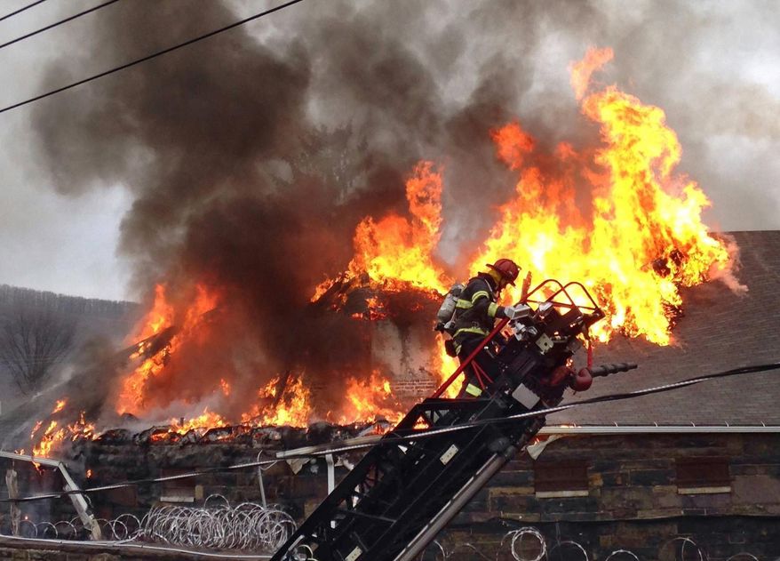 Flames shoot through the roof of the Northumberland County Prison in Sunbury, Pa. on Wednesday, Jan. 14, 2015. Dispatchers say the blaze was reported just after 2 p.m. at the nearly 140-year-old jail in the city of 10,000 about 40 miles north of Harrisburg, Pa. (AP Photo/News-Item, Larry Deklinski)