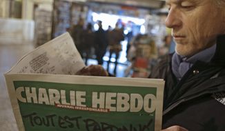 Jean Paul Bierlein reads the latest issue of Charlie Hebdo outside a newsstand in Nice, southeastern France, Wednesday, Jan. 14, 2015. (AP Photo/Lionel Cironneau) 