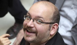 Jason Rezaian, an Iranian-American correspondent for The Washington Post, smiles as he attends a presidential campaign of President Hassan Rouhani in Tehran on April 11, 2013. The reporter has been detained in Iran for more than four months and was formally charged Dec. 6, 2014, after a daylong proceeding in a Tehran courtroom, the newspaper reported. (Associated Press) **FILE**
