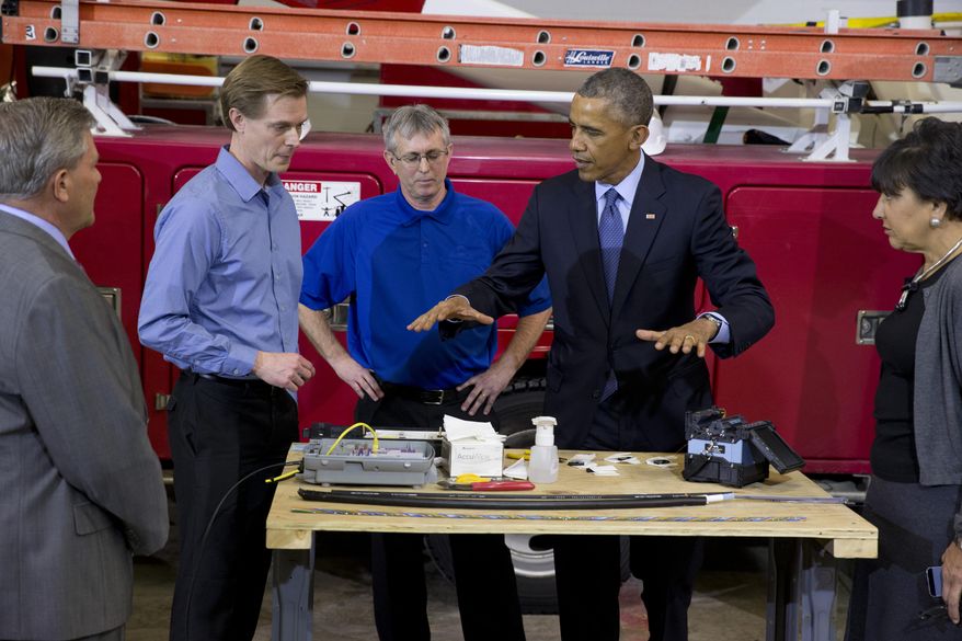 President Barack Obama, joined by Robert Houlihan, Chief Technology Officer at Cedar Falls Utilities, second from left, and David Schilling, Communications Services Manager at Cedar Falls Utilities, third from left and Commerce Secretary Penny Pritzker, attends a fiber optic splicing demonstration at Cedar Falls Utilities, in Cedar Falls, Iowa., Wednesday, Jan. 14, 2015, before speaking about steps to increase access to affordable, high-speed broadband across the country. (AP Photo/Carolyn Kaster)