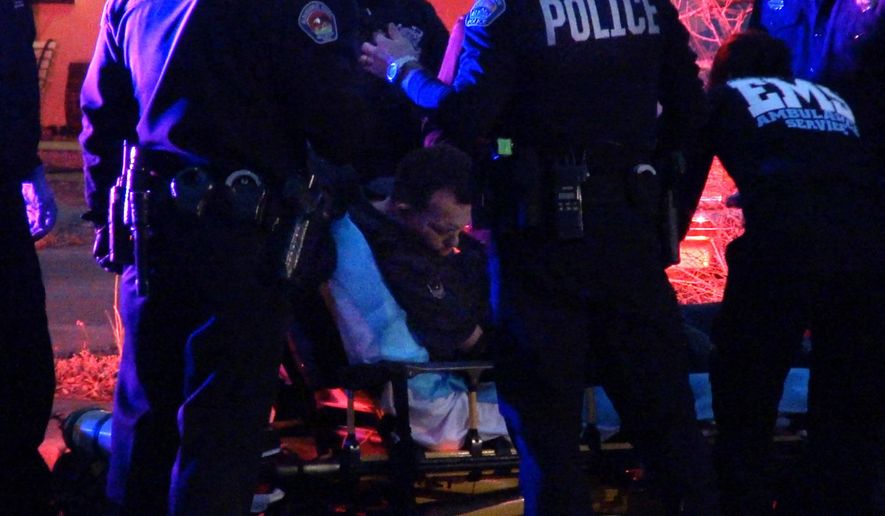In this frame grab taken from video, medical personal assist a man before transporting him to an ambulance in Albuquerque, N.M., Tuesday, Jan. 13, 2015. Just a day after a district attorney announced murder charges against two Albuquerque police officers, authorities said another city police officer fired his weapon Tuesday night. But authorities declined to say if anyone was killed or if anyone was shot. (AP Photo/The Albuquerque Journal, Pat Vasquez-Cunningham)