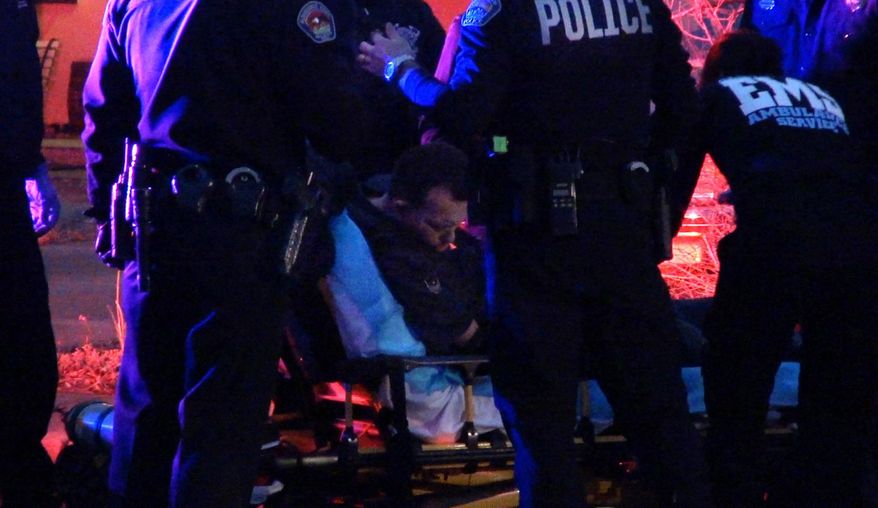 In this frame grab taken from video, medical personal assist a man before transporting him to an ambulance in Albuquerque, N.M., Tuesday, Jan. 13, 2015. Just a day after a district attorney announced murder charges against two Albuquerque police officers, authorities said another city police officer fired his weapon Tuesday night. But authorities declined to say if anyone was killed or if anyone was shot. (AP Photo/The Albuquerque Journal, Pat Vasquez-Cunningham)