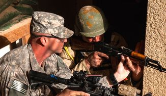 Sgt. Jeremiah Walden, an infantry trainer assigned to A Co., 2nd Bn., 34th Armor Regt., 1st Armored Brigade Combat Team, 1st Infantry Division, adjusts an Iraqi trainee&#39;s weapon to ensure he&#39;s covering the correct sector of fire during infantry squad tactical training lanes Jan. 7 at Camp Taji, Iraq. Walden is one of over 150 &quot;Dreadnaughts&quot; of 2-34 who are advising several Iraqi Army battalions, providing new recruits advanced training and assisting Iraqi cadre by teaching small unit tactics and leadership. (U.S. Army photo by Master Sgt. Mike Lavigne, 1st Inf. Div. PAO)