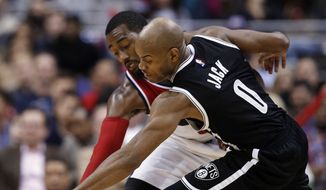Washington Wizards guard John Wall (2) attempts to steal the ball from Brooklyn Nets guard Jarrett Jack (0) during the second half of an NBA basketball game, Friday, Jan. 16, 2015, in Washington. Jack maintained possession. The Nets won 102-80.(AP Photo/Alex Brandon)