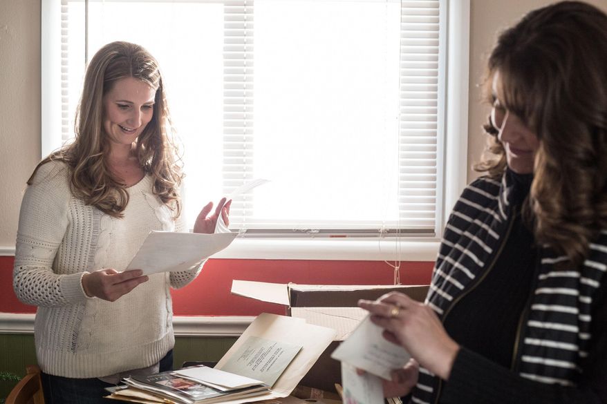 In this photo taken Friday, Jan. 9, 2015, Rev. James Reeb's granddaughters Leah Reeb,l eft, and Corrie Lubenow look through news clippings in Casper, Wyo., about their late grandfather in Casper, Wyo. A white minister raised in Casper, Reeb was murdered by white supremacists during the Selma, Ala., protests. Word of his death spread worldwide and influenced Congress' decision to pass the Voting Rights Act of 1965, prohibiting racial discrimination in voting. (AP Photo/The Casper Star-Tribune, Ryan Dorgan)