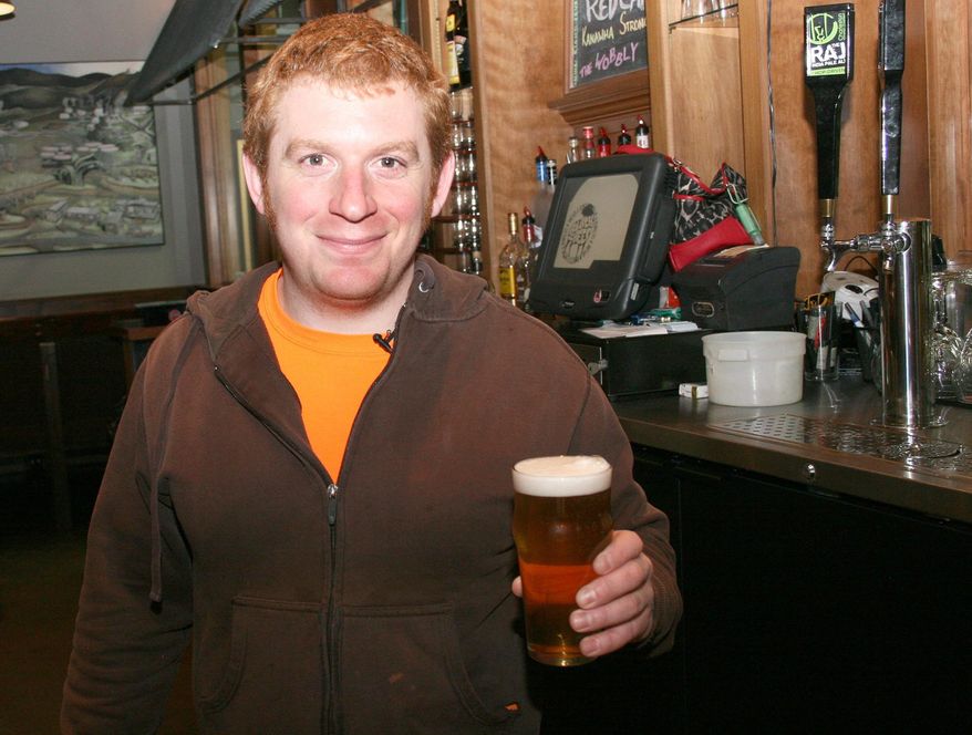 ADVANCED FOR RELEASE SATURDAY, JANUARY 17, 2015 Ryan Heastings, head brewer at Black Sheep Burrito and Brews, poses for a photo holding one of several brews on tap in Charleston, W.Va., Jan. 11, 2015. (AP Photo/Charleston Daily Mail, Billy Wolfe)