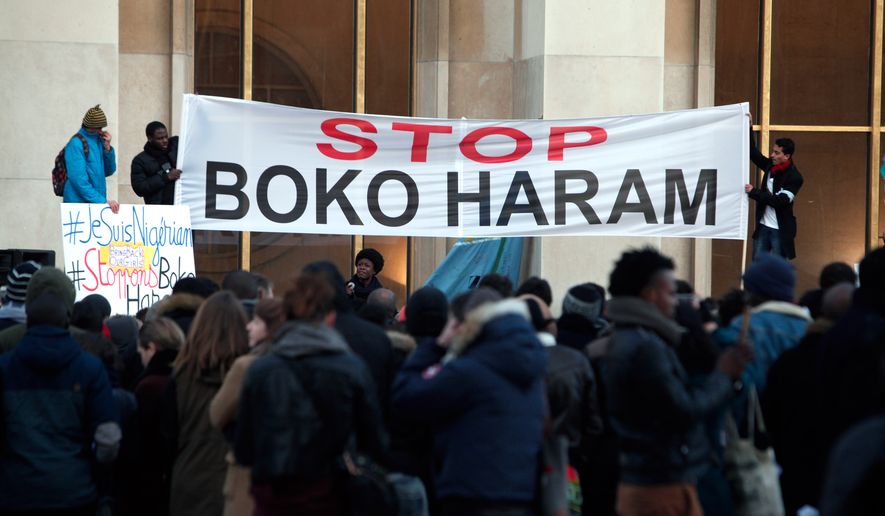Men hold a banner during a gathering at the Trocadero place, in Paris, Sunday, Jan. 18, 2015 to protest against extremist Islamic group Boko Haram after a large-scale attack in Baga, where as many as 2,000 people were massacred in a raid on January 7, 2015. Cameroon, Chad and Niger have launched a regional bid to combat the Boko Haram. (AP Photo/Thibault Camus)