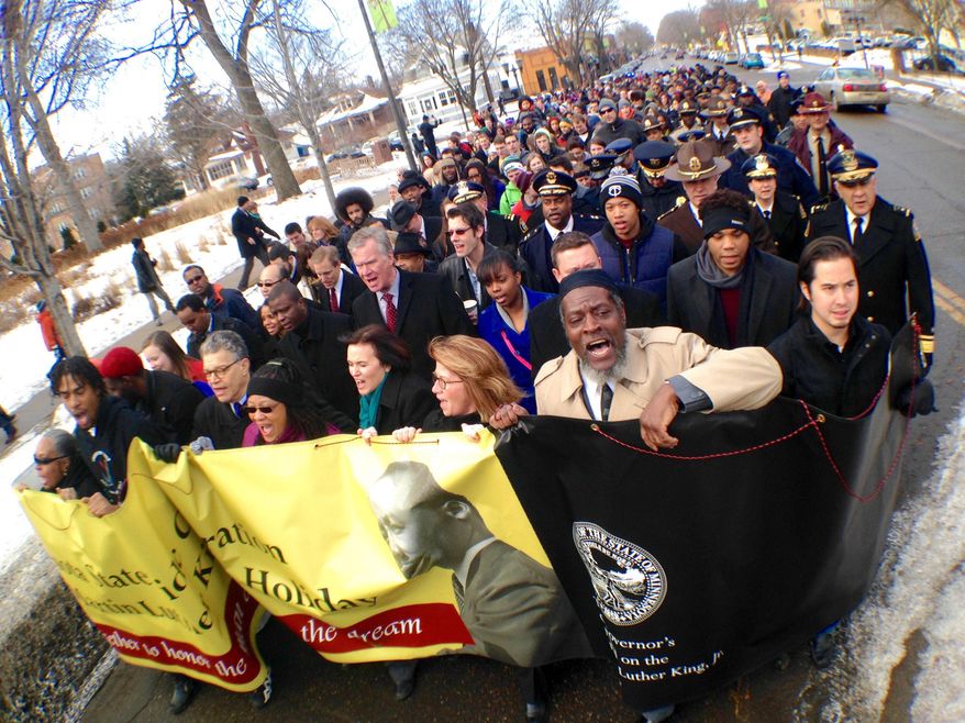 People march during a re-enactment to honor Rev. Martin Luther King Jr., Monday, Jan. 19, 2015, at Macalester College in St. Paul, Minn. (AP Photo/The St. Paul Pioneer Press, Ben Garvin) MINNEAPOLIS STAR TRIBUNE OUT