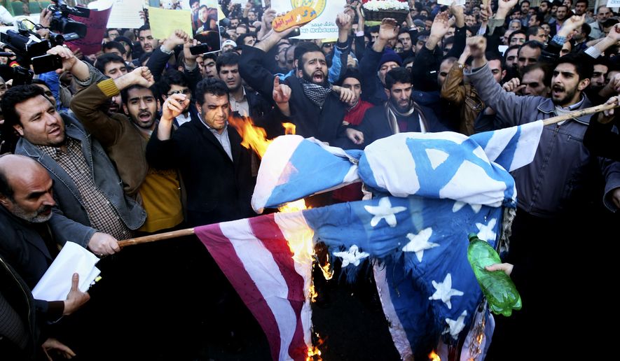 Iranian demonstrators burn representations of Israeli and U.S. flags during a rally against the satirical magazine Charlie Hebdo&amp;#8217;s latest publication of a cartoon depicting the Prophet Muhammad, which some Muslims deem an insult to Islam, in front of the French Embassy, Tehran, Iran, Monday, Jan. 19, 2015. (AP Photo/Ebrahim Noroozi)