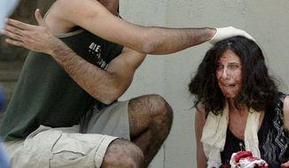 In this July 31, 2002, file photo, a man helps a wounded woman near the scene of an explosion at the Hebrew University in Jerusalem where a bomb exploded in the crowded cafeteria that killed nine people and wounded more than 70. Testimony opened in the week of Jan. 12, 2015, for a $1 billion lawsuit brought by U.S. terrorism victims against the Palestinian Authority and the Palestine Liberation Organization. The case is one of three major cases proceeding through New York federal courts under the Anti-Terrorism Act: a federal law letting victims of terrorism seek compensation. (AP Photo/David Guttenfelder, File)