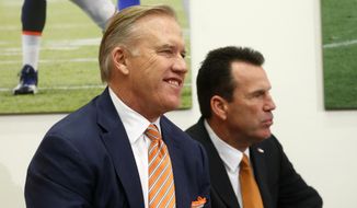 John Elway, left, Denver Broncos general manager and executive vice president of football operations, smiles before introducing Gary Kubiak, right, as the new head coach of the Broncos during am NFL football news conference, Tuesday, Jan. 20, 2015, in Englewood, Colo. (AP Photo/Jack Dempsey)