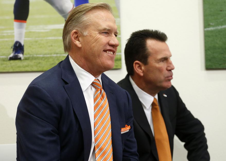 John Elway, left, Denver Broncos general manager and executive vice president of football operations, smiles before introducing Gary Kubiak, right, as the new head coach of the Broncos during am NFL football news conference, Tuesday, Jan. 20, 2015, in Englewood, Colo. (AP Photo/Jack Dempsey)
