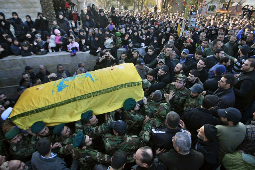 Hezbollah fighters carry the coffin of Hezbollah member Mohammad Issa — who was killed in an airstrike in Syria that killed six members of the Lebanese militant group and an Iranian general — during his funeral procession, in the southern village of Arab Salim, Lebanon, Tuesday, Jan. 20, 2015. (AP Photo/Mohammed Zaatari)